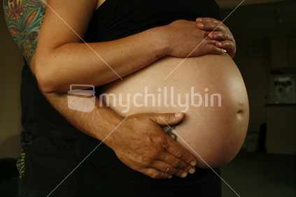 Expectant mother and father holding their unborn child during the third trimester of  pregnancy.