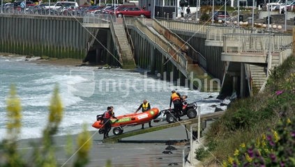 Surf lifesavers, launching or retrieving an inflatable rescue boat. St Clair, Dunedin. 