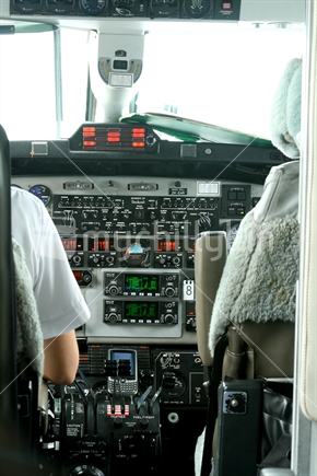 A view of the control panel of a small plane, with pilot seated.