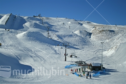 People waiting and riding a ski lift at Snowpark ski field, Central Otago,