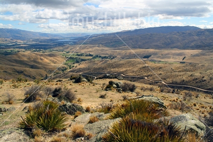 Expansive view across rugged hills of Central Otago, with Lake Dunstan in the distance.