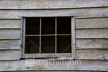 An old wooden window frame in a wooden weatherboard building.