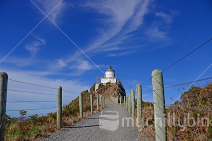 Winding pathway to Nugget Point lighthouse, flanked by safety fence.