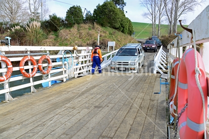 Rush hour; loading vehicles and passengers onto the Tuapeka Mouth Ferry, to cross the Clutha River.