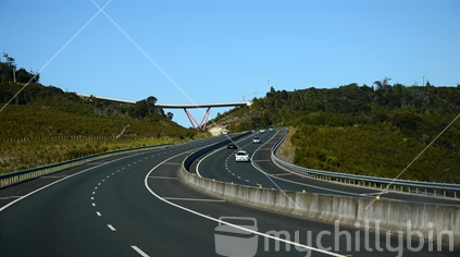 The curving road of Orewa bypass, with overbridge in the distance.