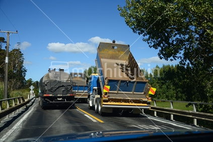 Tar and metal trucks at work, resealing state highway 1, south of Hukeranui, Northland.