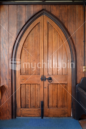 A beautifully restored arched wooden door, the entrance of Waimate North Parish church.