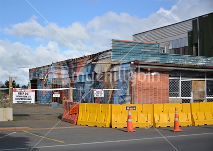 Yellow barriers and fencing, secure the demolition site of the historic Kaikohe Hotel, Northland.