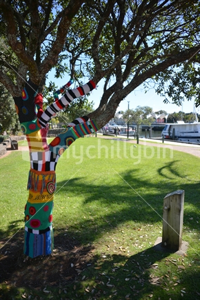 Artist work wrapped around the branches and trunk of a pohutukawa tree in the town basin of Whangarei CBD.