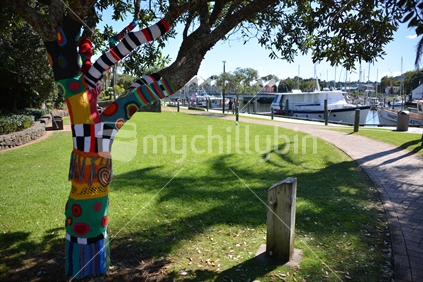 To bring a smile, someone has knitted and wrapped the branches and trunk of a pohutukawa tree in the town basin in Whangarei with bright knitting.