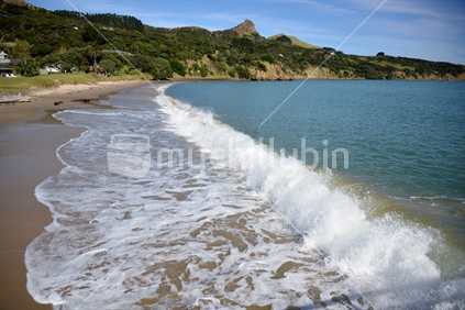 Waves lapping along the shore of Omapere Beach.