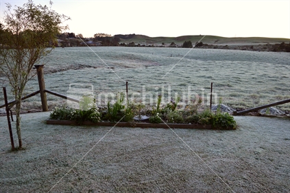 A good covering of snow on garden, lawn and farmland in the background.