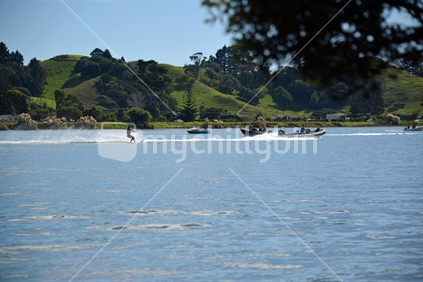 Water skiing at full tide in Whananaki Estuary with Northern township in the background.
