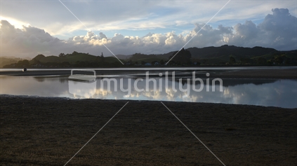 Beautiful reflections of Whananaki North and hills, in ebbing estuary waters.
