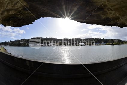 Whangarei Harbour on a clear day framed by a stone sculpture .