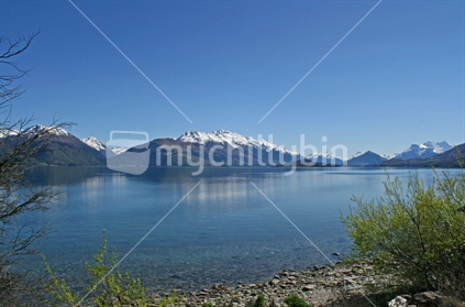 Looking across Lake Wakatipu to snow capped mountains, on the road to Glenorchy, New Zealand