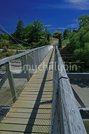 Leading lines of a suspension footbridge constructed of wood and wire mesh.