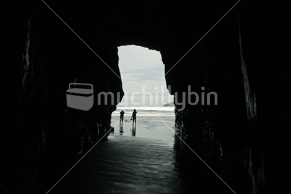 Looking from the interior of Cathedral Caves, outward to people gathered on the beach. Catlins, South Island.