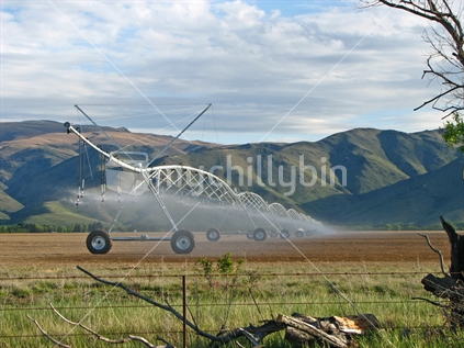 Newly ploughed ground being watered with large irrigation system, Central Otago, South Island.