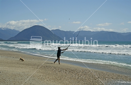 A man surfcasting on a West Coast beach, South Island.