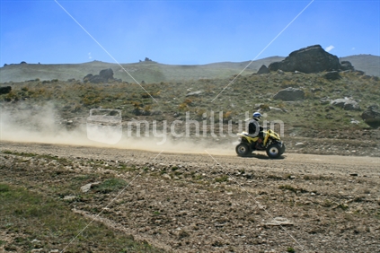 An exhilirating ride on a quad bike along a New Zealand high country dusty dirt track.