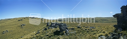 Dramatic contrasts of towering schist rock, soft tussock grass and clear blue skies, Central Otago high country farming.
