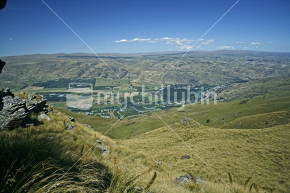 Dramatic contrasts of towering schist rock, soft tussock grass and clear blue skies, Central Otago highcountry farming.