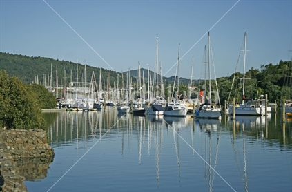 Early morning reflections of moored boats in a marina, Northland.
