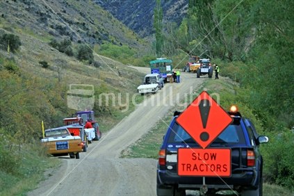 The tail end of tractors from 2010 fundraising Tractor Trek, with pilot vehicle, stopped on the roadside on the Nevis Road, Central Otago.