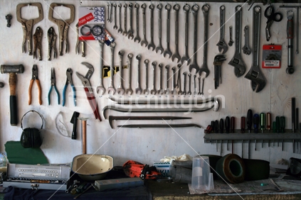 A well organised wall of tools and workbench in a typical kiwi blokes shed.