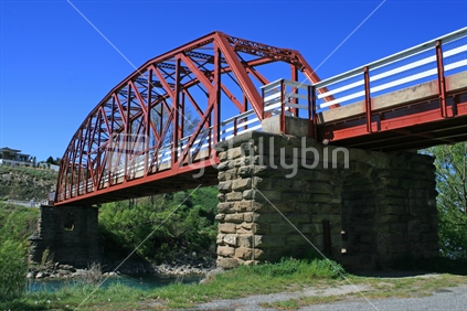 Clyde bridge on massive stone pillars, from below, with clear blue skies.  Central Otago, South Island,