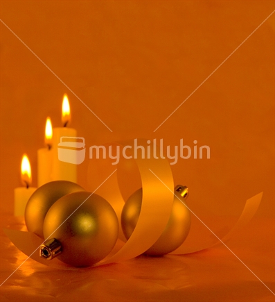 Image of three candles and festive ball decorations with ribbon, portrait orientation, orange color