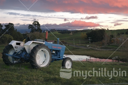 Rural scene featuring blue tractor