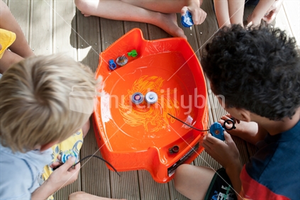 Friends playing spinning Beyblades