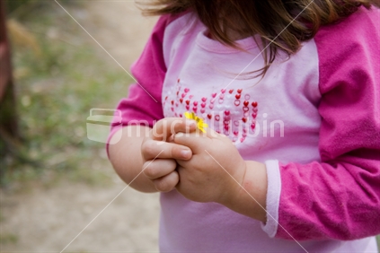Little girl holding on to flower