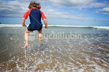 Boy jumping wave