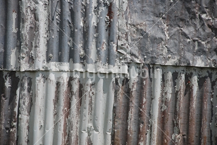 An dented and rusty corrugated iron wall