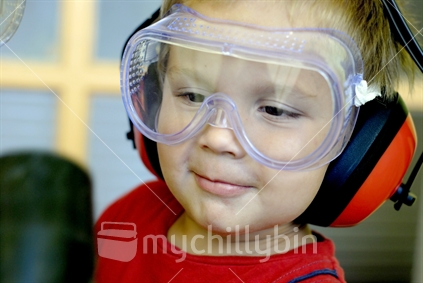 A young boy wearing goggles and earmuffs
