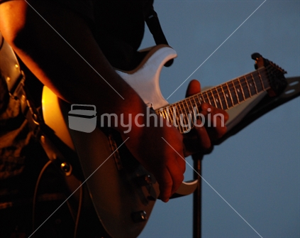 A man plays an electric guitar