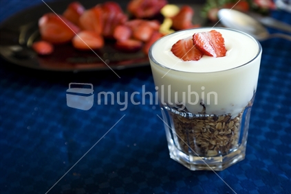 A healthy breakfast of yogurt and muesli with sliced strawberries