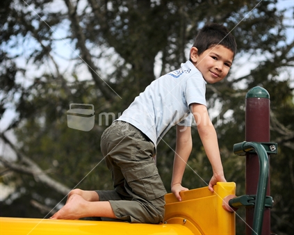 A boy climbs a playground