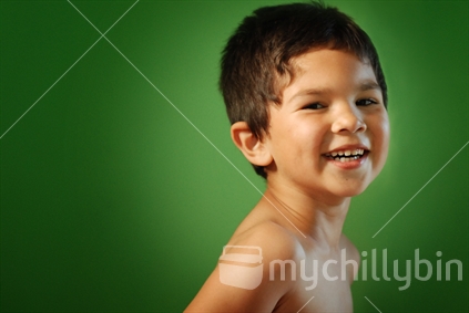 A happy young boy on a green background