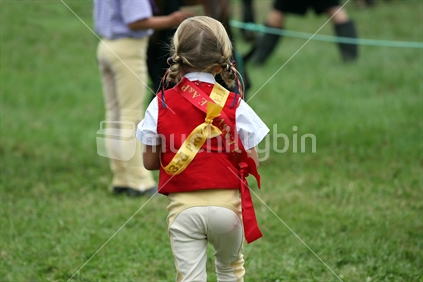Young girl with ribbons won in equestrian section of the Helensville A&P Show, north of Auckland, New Zealand.