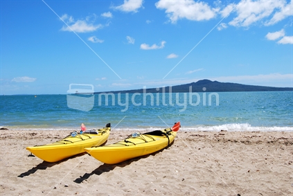 Kayaks at Mission Bay with Rangitoto Island in the background. New Zealand