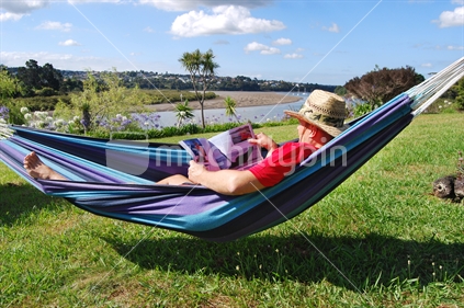 Man in a hammock, reading a fishing magazine