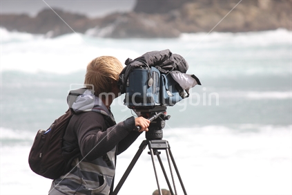 Cameraman filming an event at the beach