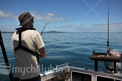Fishing in the Hauraki Gulf with Rangitoto Island in the background