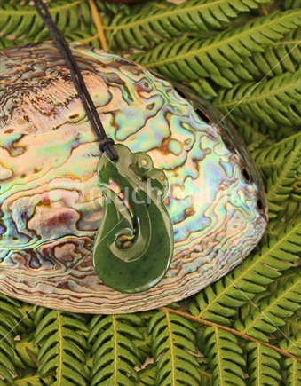 Pounamu pendant and Paua shell on fern leaves
