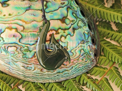 Pounamu pendant and Paua shell on fern leaves