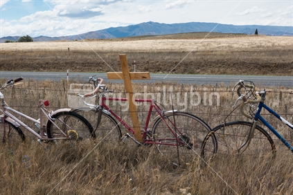 Old bike graveyard, complete with cross, on the roadside near the Clyde Rail Trail 